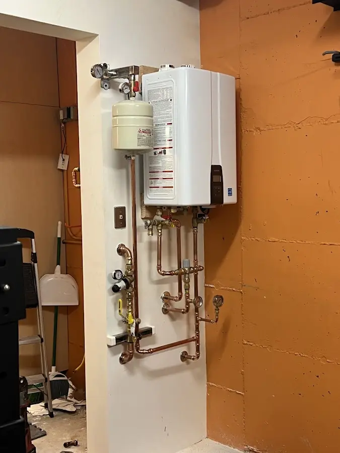 Plumbing technician inspecting water heater connections in Hood River
